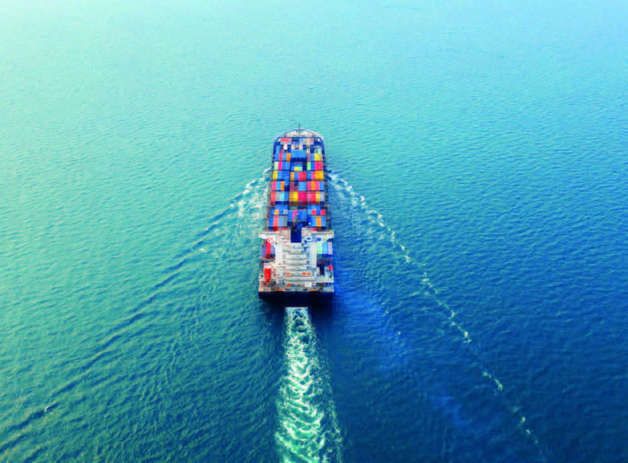 An aerial view of a container ship navigating the open seas, illustrating global cargo transport and maritime operations.